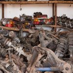 Regale und Stapel mit gebrauchten Fahrzeugteilen in einem Lagerraum