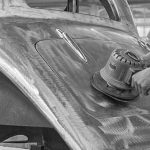 Arbeiter schleift eine rohe Karosserie im Borgward-Werk