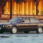 BMW 750i der Baureihe E32 in dunkler Lackierung, Seitenansicht auf Kopfsteinpflaster