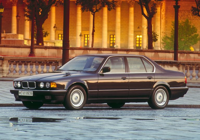 BMW 750i der Baureihe E32 in dunkler Lackierung, Seitenansicht auf Kopfsteinpflaster