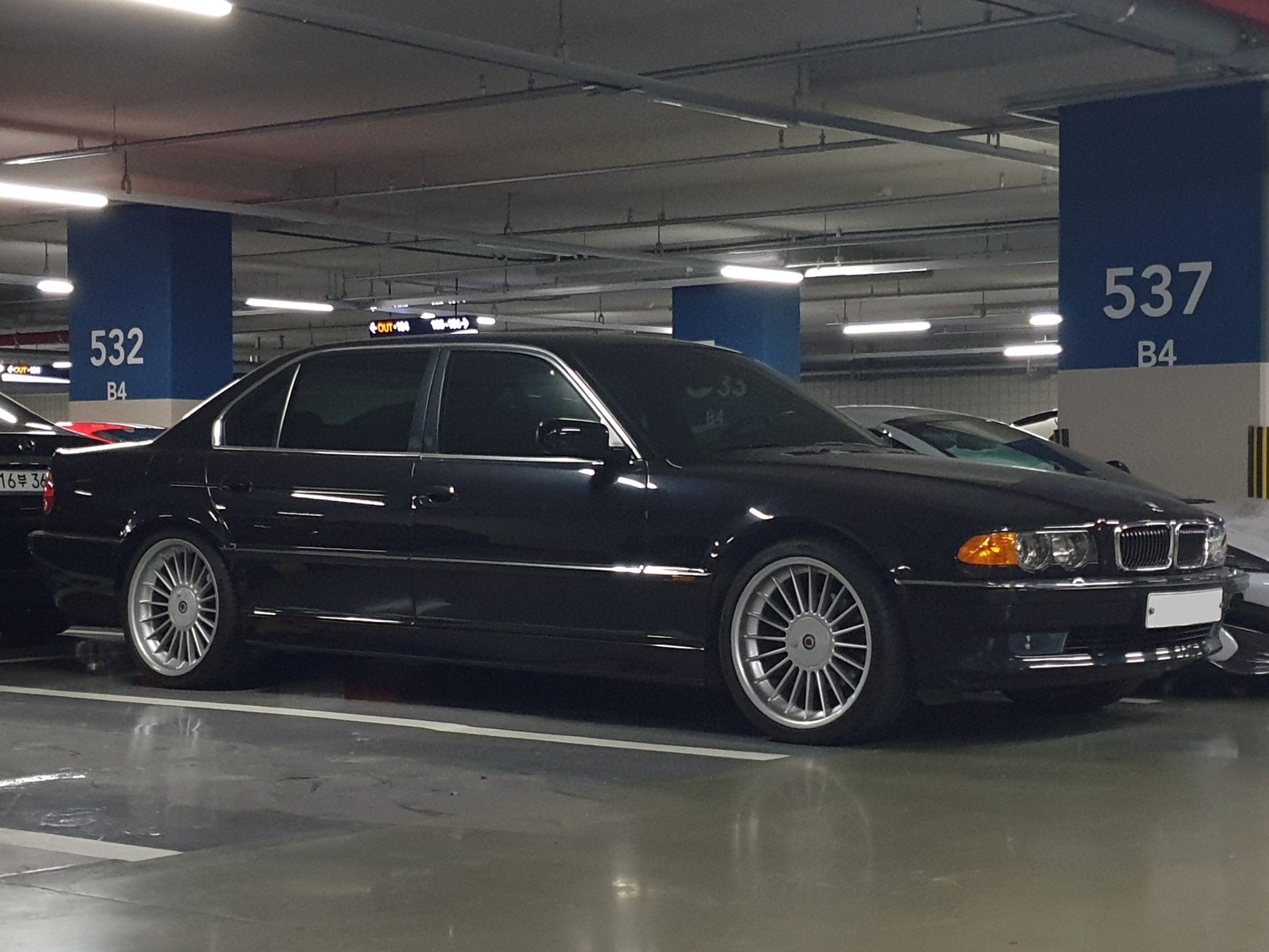Schwarzer BMW 735iL der Baureihe E38 der zweiten Serie in einer Tiefgarage