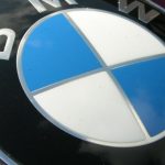 Blau-weiss geviertelter BMW-Kreis auf dunkelroter Motorhaube