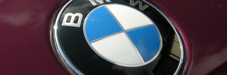 Blau-weiss geviertelter BMW-Kreis auf dunkelroter Motorhaube