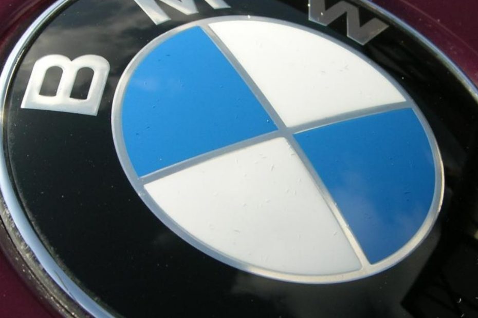 Blau-weiss geviertelter BMW-Kreis auf dunkelroter Motorhaube