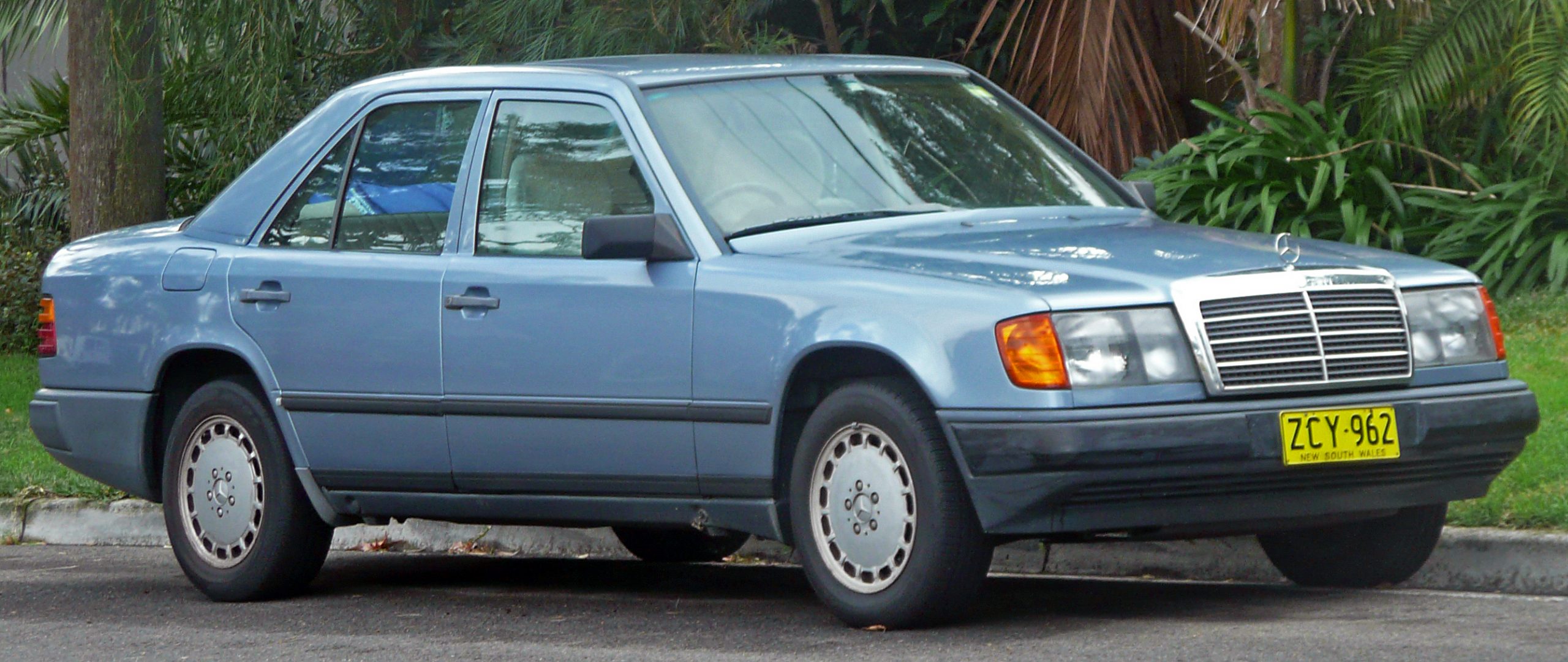 Hellblauer Mercedes-Benz 300 E der Baureihe W 124 in Seitenansicht