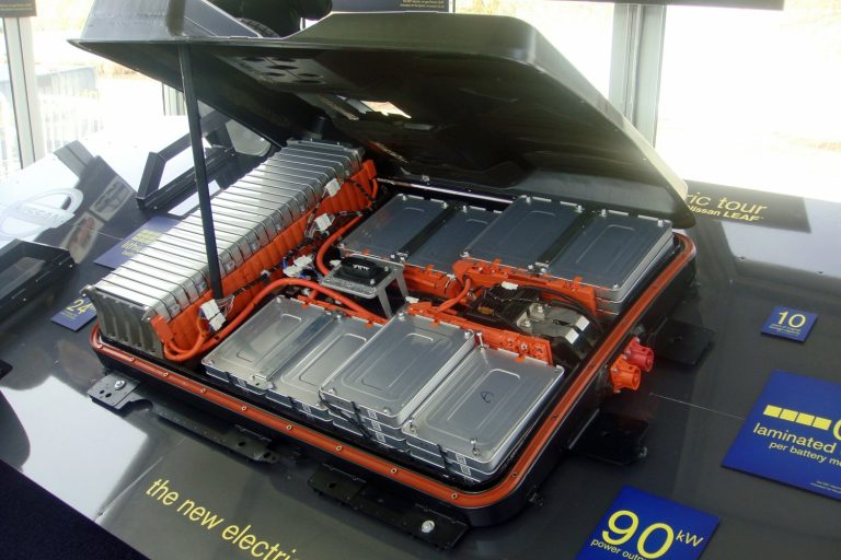 Geöffnetes Batteriepaket eines Nissan Leaf: einzelne Module, orangefarbene Zellverbinder und Anschlusskasten